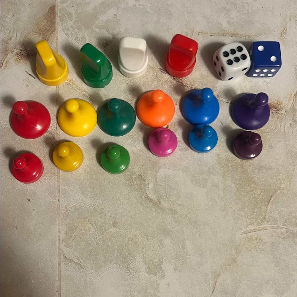 Assortment items are replacement game pieces and dice. Colorful plastic pieces